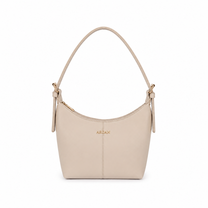 A light beige leather shoulder bag with a curved top, a single shoulder strap, and a small gold-tone 'ALEXAN' logo on the front, set against a plain white background.