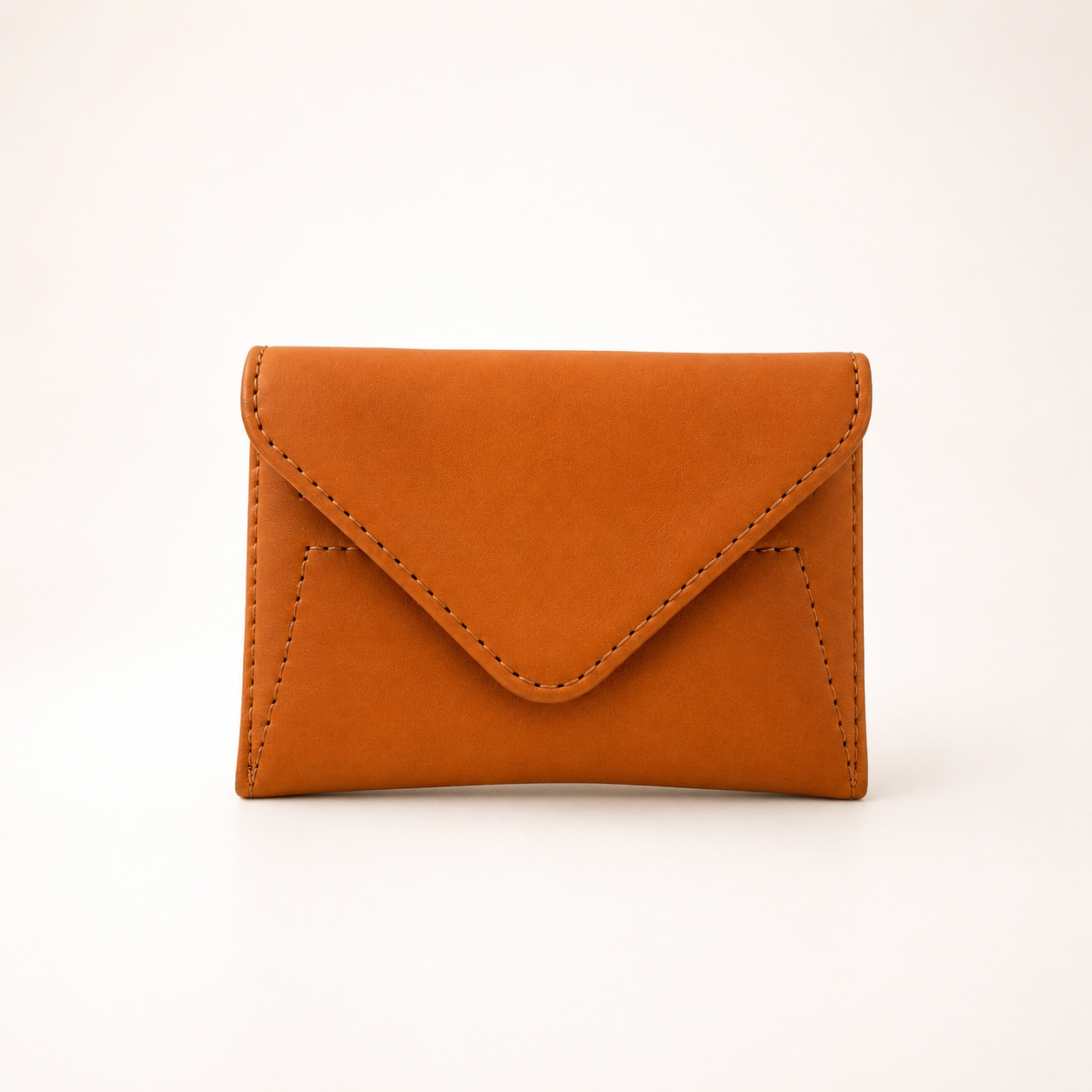 A small envelope-style card holder wallet in warm cognac brown faux leather, shown on a clean white background.