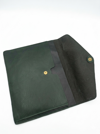 A dark green leather sleeve or clutch with a black fabric interior lining and gold-tone snap buttons, shown open on a white background.