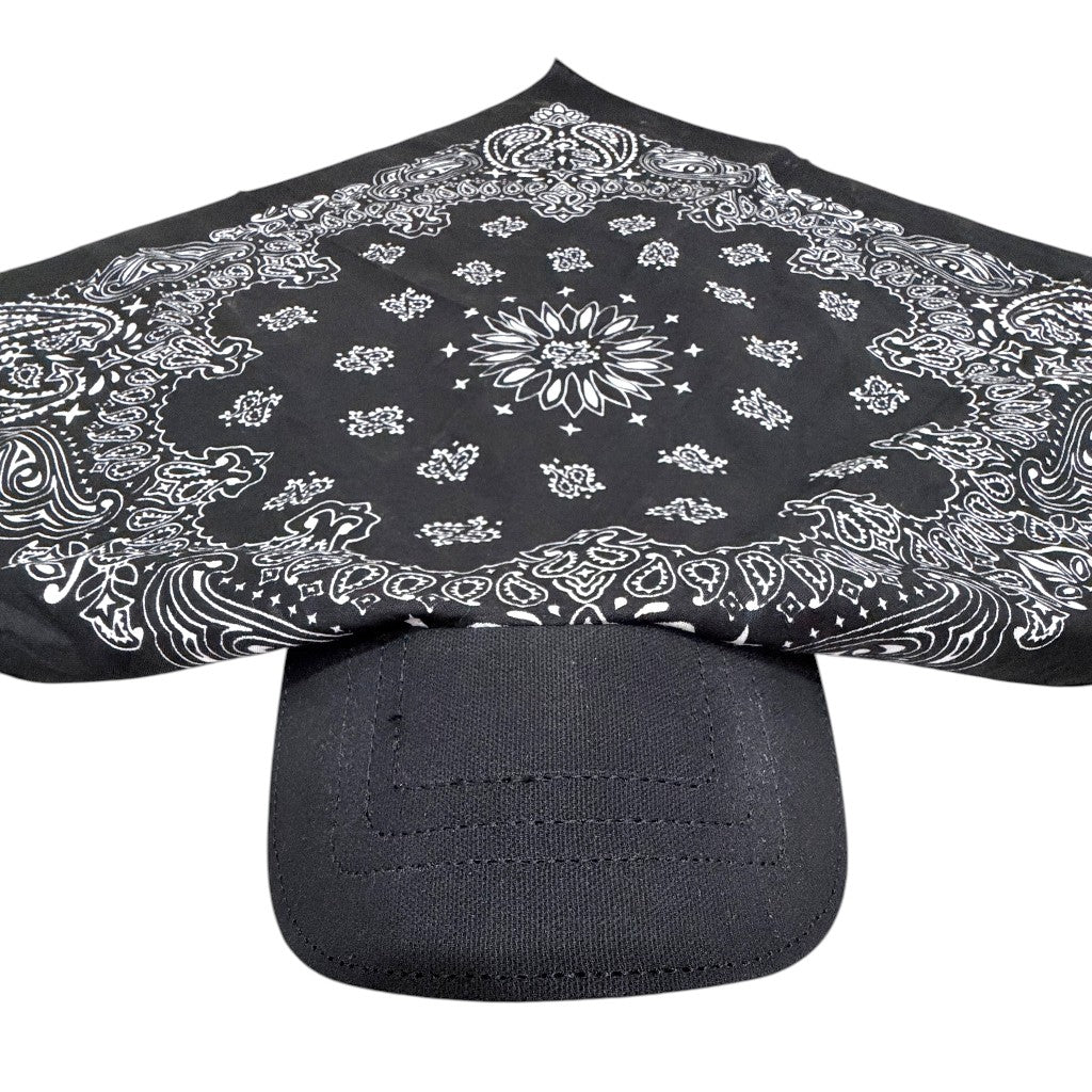 A black bandana with a white paisley pattern draped over the brim of a black baseball cap, shown against a plain white background.