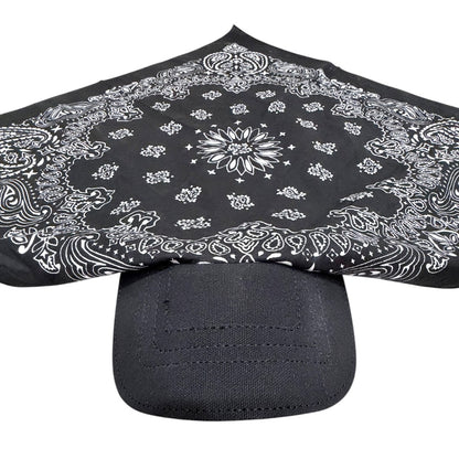 A black bandana with a white paisley pattern draped over the brim of a black baseball cap, shown against a plain white background.